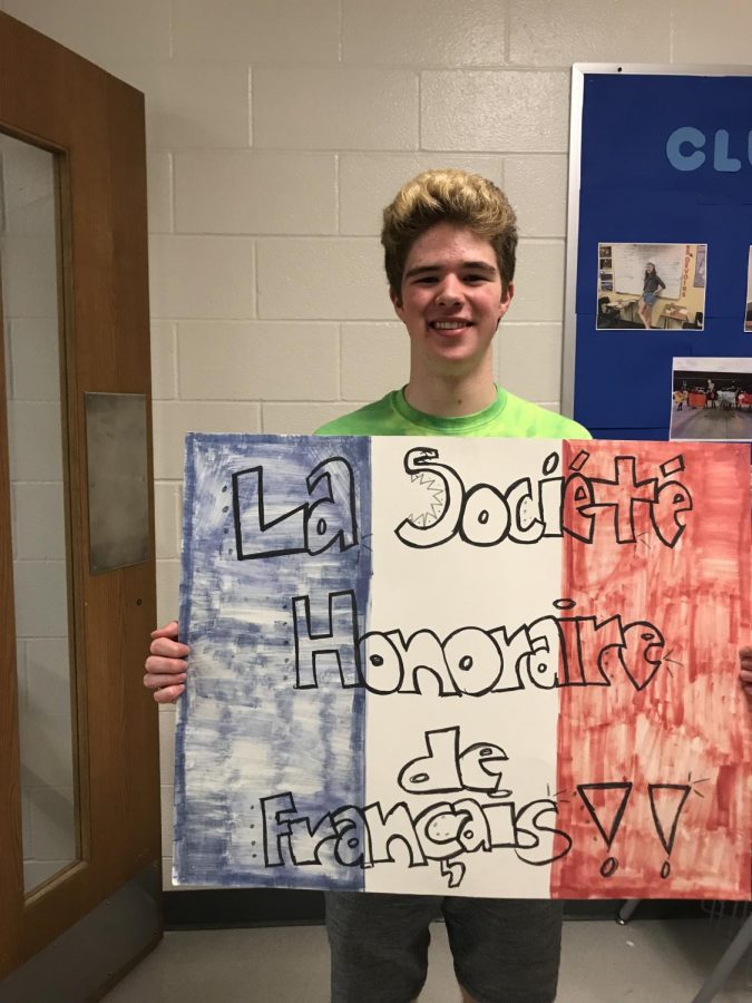 Junior Michael Adamson holds a French National Honor Society sign. 