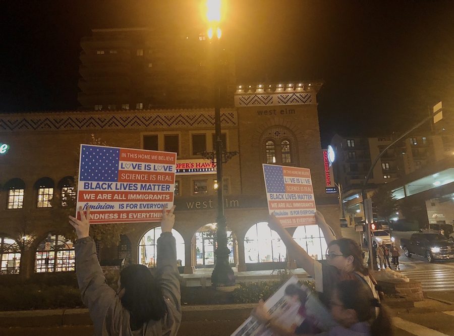 Two teen protestors carry signs advocating for the Black Lives Matter movement and other causes at the Country Club Plaza in downtown Kansas City, MO on Nov 7, 2020. Photo by Arshiya Pant. 
