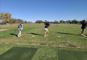 Carlie Kidwell and Olivia Still warmup for the tournament at the driving range. Photo provided by Olivia Still.