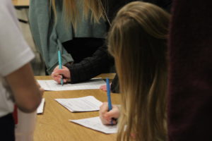 Students sign interest papers.