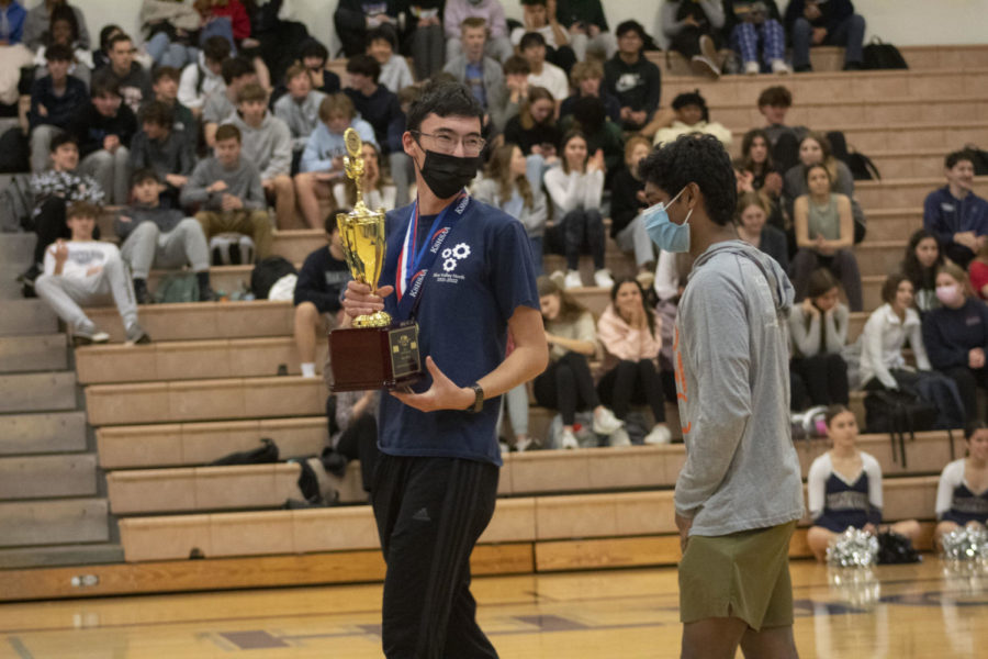 Senior Luke Chen raising the Science Olympiad State trophy at the Apr. 7 spring sports assembly.